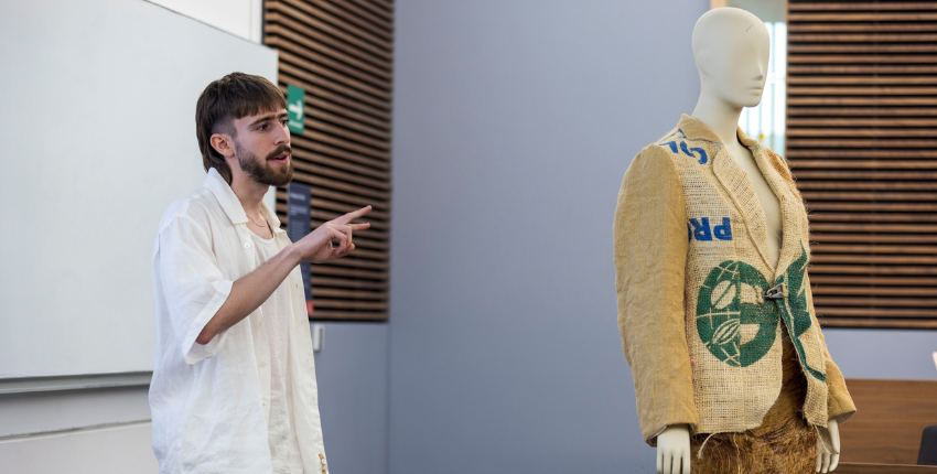 Estudiante de diseño de modas exponiendo un diseño moda sustentable