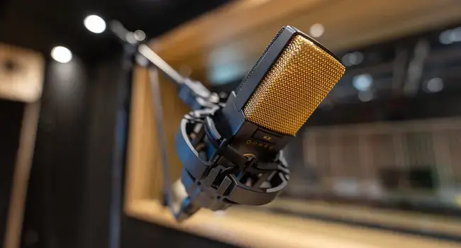 En el fondo de un estudio de grabación un micrófono amarillo y negro 
