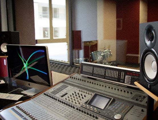 Consola de sonido y pantalla en el cuarto de grabación de música.
