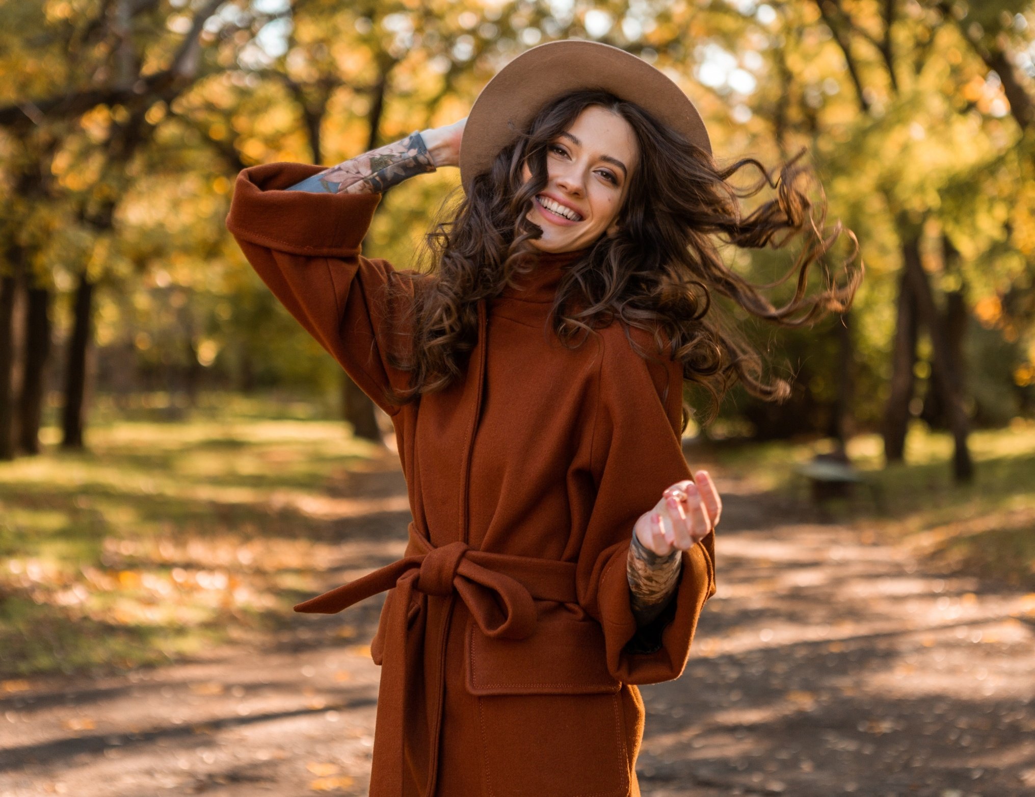 Mujer feliz en un paisaje otoñal con el diseño de moda de temporada