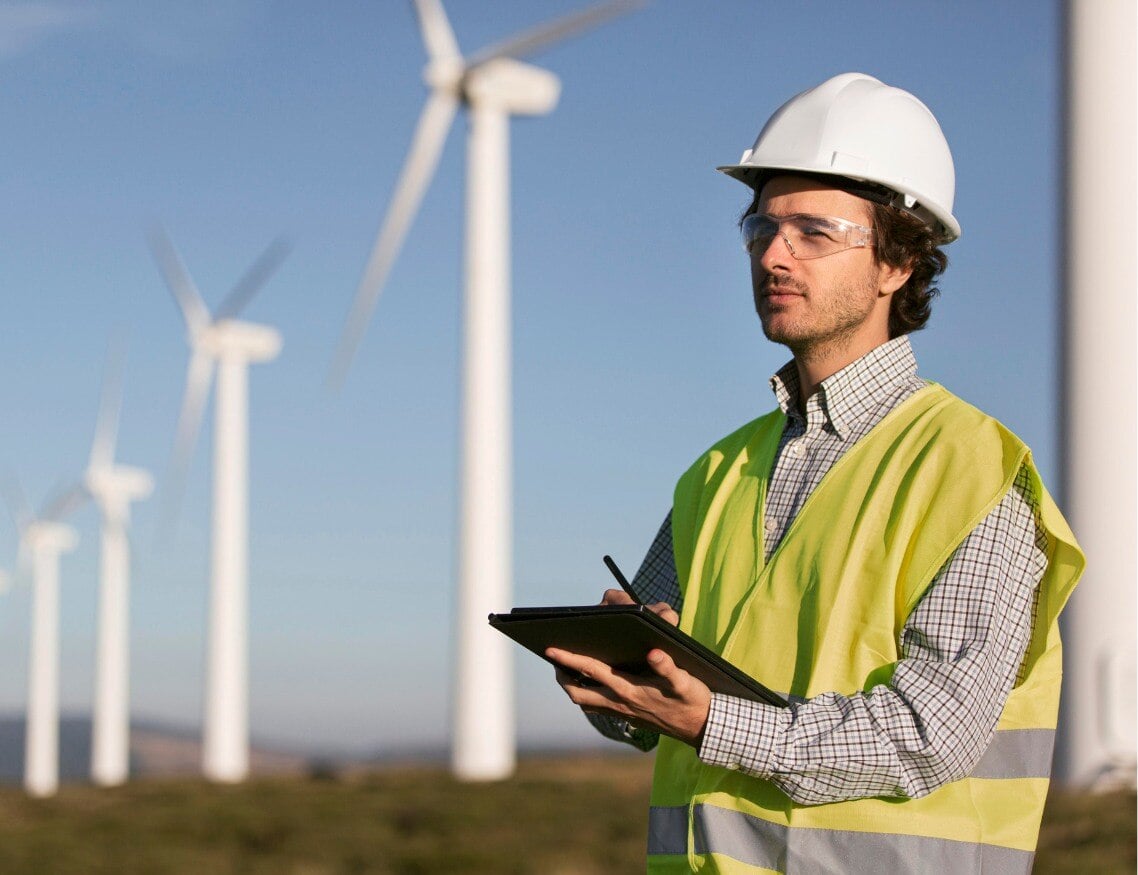 Ingeniero ambiental trabajando y tomando nota en campos de parques eólicos