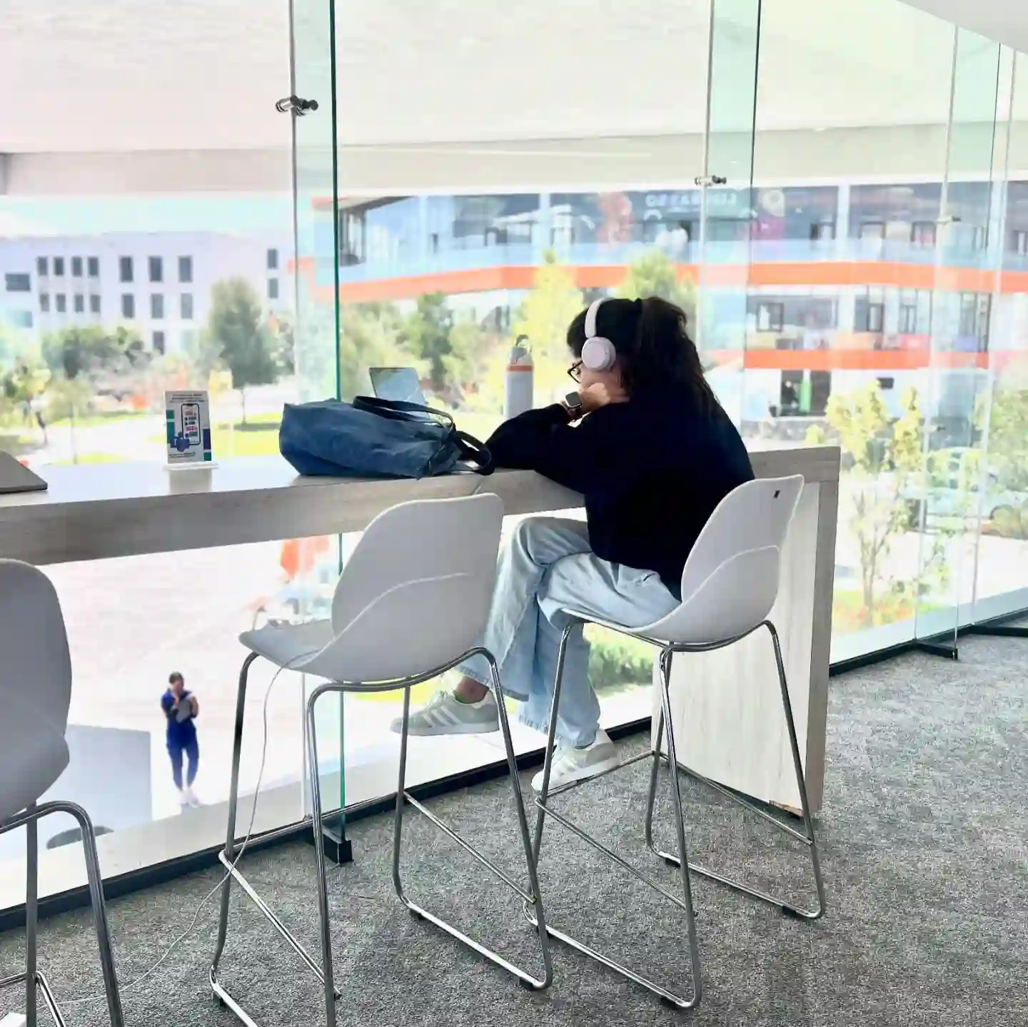 Estudiante en biblioteca contemplando que estudiar en la universidad