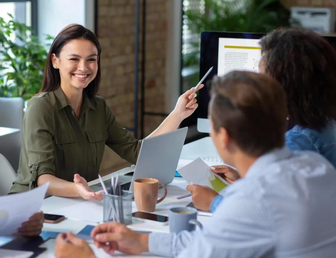 Pedagoga joven mostrando datos y resultados positivos a miembros de la organización donde trabaja